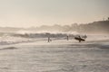 Silhouettes of a people and surfers at the beach.