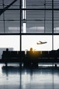 Silhouettes of people waiting at the plane boarding gates. Royalty Free Stock Photo