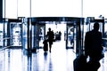 Silhouettes of people walking in airport. Royalty Free Stock Photo