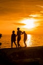 Silhouettes of people walking on the beach at sunset Royalty Free Stock Photo