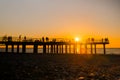 Silhouettes Of People Are Walking On The Pier Against Dramatic Sunset Sky