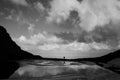 Silhouettes of 2 people walking together on the shore of a glacial lake, located at high altitude Royalty Free Stock Photo