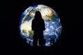 Silhouettes of people and young woman standing in front of large inflatable model of planet Earth glowing at night, view from Royalty Free Stock Photo