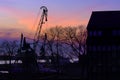 Silhouettes of port crane, trees and building in beautiful sunset in port harbor in Klaipeda, Lithuania.