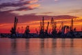 Silhouettes of port cranes at stunning red sunset. Royalty Free Stock Photo