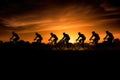 Silhouettes of professional cyclists on road at sunset. Generative AI