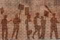 Silhouettes of protesting people against the the flag of Barcelona on the break wall background