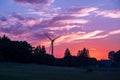 silhouettes of the rotating blades of a windmill propeller against the sunset sky. Wind energy production. Clean green energy Royalty Free Stock Photo