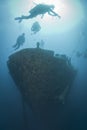 Silhouettes of scuba divers exploring a shipwreck. Royalty Free Stock Photo