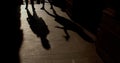 Silhouettes shadows people on sidewalk in city. They move their arms and legs. Royalty Free Stock Photo