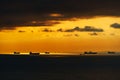 Silhouettes of ships at sea against a bright sunset sky, sunlight reflected from the waves, dramatic sky Royalty Free Stock Photo