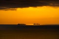 Silhouettes of ships at sea, dramatic seascape with sunset sky, sunlight reflected from the waves Royalty Free Stock Photo