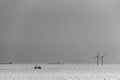 Silhouettes of a shrimp cutter, two cargo ships and two wind turbines in the north sea Royalty Free Stock Photo