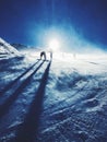 Silhouettes of snowboarders on a ski slope with a snowy sun Royalty Free Stock Photo