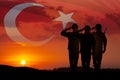 Silhouettes of soldiers on a background of Turkey flag and the sunset or the sunrise.