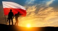 Silhouettes of soldiers with national flag on background of sunset. Polish Armed Forces.