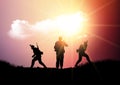 Silhouettes of soldiers on patrol in sunset landscape