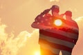 Silhouettes of soldiers with print of sunset and USA flag saluting on a background of light sky. Royalty Free Stock Photo