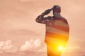 Silhouettes of soldiers with print of sunset and USA flag saluting on a background of light sky. Royalty Free Stock Photo