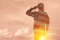 Silhouettes of soldiers with print of sunset and USA flag saluting on a background of light sky. Royalty Free Stock Photo