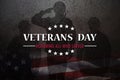 Silhouettes of soldiers saluting with Veterans Day inscription on rusty iron background.