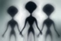 Silhouettes of spooky aliens and bright light on behind them