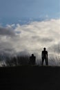 Prague, Czech Republic, January 2015. Blue sky with dark clouds and stone figures among the bushes.