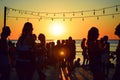 Silhouettes sway in a vibrant sunset at a tropical beach dance party, epitomizing summer joy. Royalty Free Stock Photo