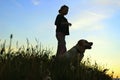 Silhouettes Of A Teenage Girl Walking With Her Pet.