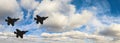 Silhouettes of three F-35 aircraft against the blue sky