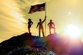 Silhouettes of three happy man on a mountain top, with flag america Royalty Free Stock Photo
