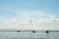 Silhouettes of three kayaks with tourists floating on the lake against the horizon. Leisure activities and sports. Royalty Free Stock Photo