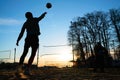 Silhouettes of three men playing beach volleyball Royalty Free Stock Photo