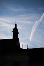 Silhouettes of towers and architectural parts with blue sky and white clouds