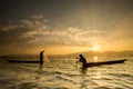 Silhouettes of the traditional fishermen throwing fishing net du