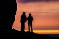 silhouettes of travellers couple standing on rocks in front Royalty Free Stock Photo