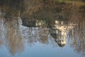 Silhouettes of trees and a church reflected in the calm waters of a city lake. Royalty Free Stock Photo