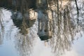 Silhouettes of trees and a church reflected in the calm waters of a city lake. Royalty Free Stock Photo