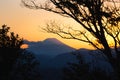 Silhouettes of trees and hills with the Mount Fuji against the sunset in the background