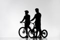 silhouettes of trial bikers in helmets with bicycles