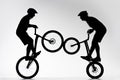 silhouettes of trial bikers performing stunt synchronously Royalty Free Stock Photo