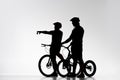 silhouettes of trial cyclists with bicycles chatting