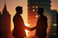 Silhouettes of two businessmen shaking hands at sunset. Royalty Free Stock Photo