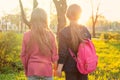 Silhouettes of two child girls walking in the park holding hands, during amazing sunset Royalty Free Stock Photo