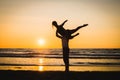 Silhouettes of two dancers doing acrobatics at sunset Royalty Free Stock Photo