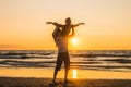 Silhouettes of two dancers doing acrobatics at sunset