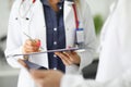 Silhouettes of two doctors in white coats one holding clipboard with pen, the second tablet. Royalty Free Stock Photo