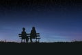 Silhouettes of two female friends sitting together and watching a spectacular night sky Royalty Free Stock Photo