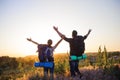 Silhouettes of two hikers with backpacks walking at sunset. Royalty Free Stock Photo