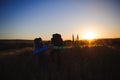 Silhouettes of two hikers with backpacks walking at sunset. Royalty Free Stock Photo